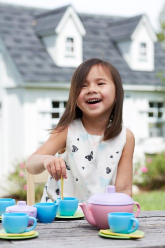 Girl playing with green toys tea set 